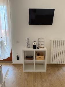 a white cabinet with a television on a wall at Milan Penthouse - Humanitas - IEO - La casa di Martina in Pieve Emanuele