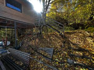 une maison avec une clôture et des feuilles sur le sol dans l'établissement Camping Kosovo Treehouse campground of anykind, à Ferizaj