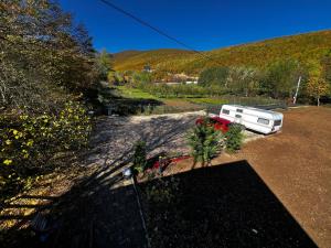 un camping-car garé dans un champ avec des arbres dans l'établissement Camping Kosovo Treehouse campground of anykind, à Ferizaj