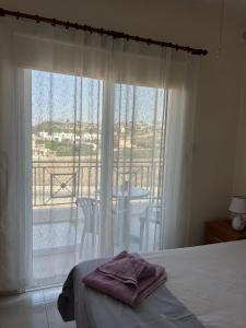 ein Schlafzimmer mit Bett und Blick auf einen Balkon in der Unterkunft Venus205 in Paphos City + 20 Fotos