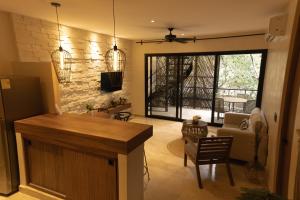 a living room with a kitchen and a dining room at Aptos Chen Luum Tulum in Tulum