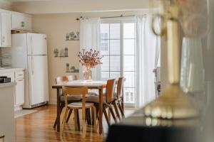 a kitchen with a table with chairs and a refrigerator at Urban Downtown Stamford Home 45 min to NYC with Garage And Yard in Stamford