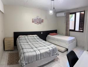 a bedroom with two beds and a chair in it at AP totalmente mobiliado, equipado e confortável in Bento Gonçalves