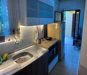 a kitchen with a sink and a refrigerator at AP totalmente mobiliado, equipado e confortável in Bento Gonçalves