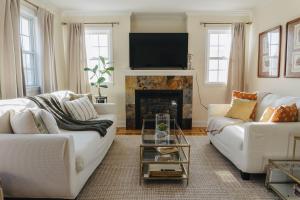 a living room with two white couches and a fireplace at Urban Downtown Stamford Home 45 min to NYC with Garage And Yard in Stamford +19 photos