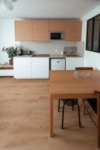 a kitchen with white cabinets and a wooden table at Studio Cosy - Bas Montreuil in Montreuil +9 photos