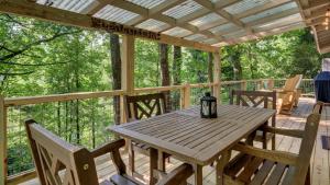 a wooden table and chairs on a deck with trees at Mountain Laurel Tree House in Highlands +8 photos
