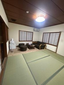 una sala de estar con un sofá y una alfombra en Suzuya, en Hanabuchihama