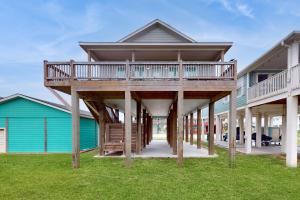 a house with a large deck on the grass at Escape Gulf Views Large Deck Group Ready in Stingaree