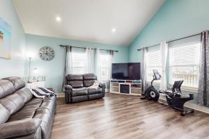 a living room with a couch and a television at Escape Gulf Views Large Deck Group Ready in Stingaree