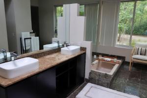 een badkamer met twee wastafels en een grote spiegel bij Stunning house - cozy & elegant in Bannockburn +34 foto's