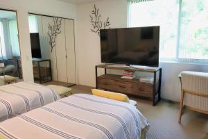 een woonkamer met 2 bedden en een flatscreen-tv bij Stunning house - cozy & elegant in Bannockburn