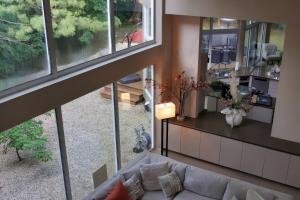 een woonkamer met een bank en ramen bij Stunning house - cozy & elegant in Bannockburn