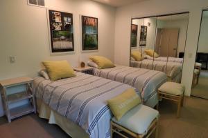 een hotelkamer met 3 bedden en een spiegel bij Stunning house - cozy & elegant in Bannockburn