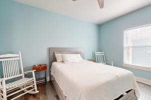 a bedroom with blue walls and a bed and a chair at Escape Gulf Views Large Deck Group Ready in Stingaree