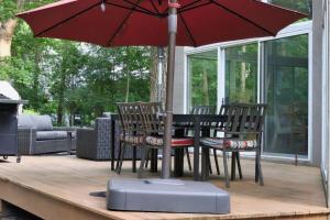 een tafel en stoelen met een parasol op een terras bij Stunning house - cozy & elegant in Bannockburn