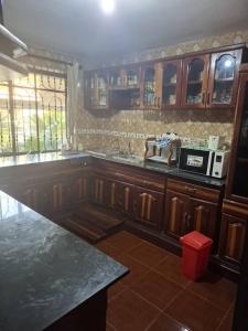 a kitchen with wooden cabinets and a counter top at P Square Apartment in Morogoro