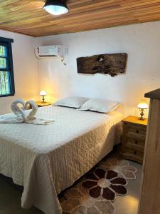 a bedroom with a bed with a white bedspread at Casa Ar Fresco in Sapiranga