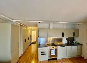 a kitchen with white cabinets and a stove top oven at Trondheim Fjord Suites Self Checkin And Out in Trondheim +38 photos