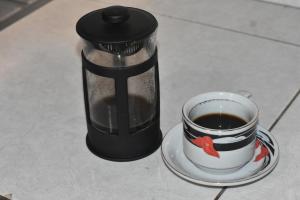 a coffee maker sitting next to a cup of coffee at Mayo Homestay in Ruteng