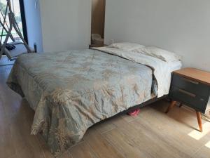 a bed in a bedroom with a wooden floor at CASA PLAYA con PISCINA in Punta Negra