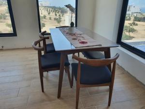a dining room table and two chairs with a table and window at CASA PLAYA con PISCINA in Punta Negra +5 photos