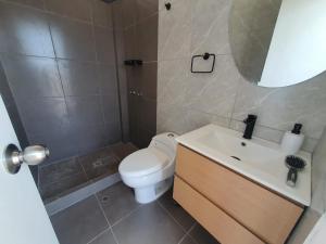 a bathroom with a toilet and a sink and a mirror at CASA PLAYA con PISCINA in Punta Negra