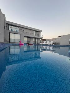 a large pool with blue water in front of a building at عمان البحر الميت in Sowayma