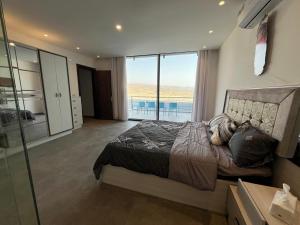 a bedroom with a bed with a view of the ocean at عمان البحر الميت in Sowayma
