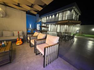 a living room with chairs and a table and an umbrella at عمان البحر الميت in Sowayma