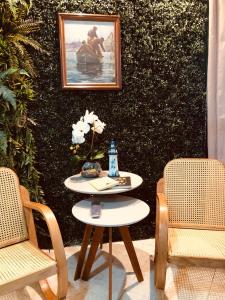 een tafel met twee stoelen en een foto aan de muur bij Flat Aconchegante em Ponta de Campina in Cabedelo