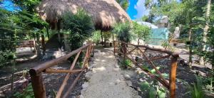 una valla de madera delante de una choza en Kóten Naj, en Chicanna