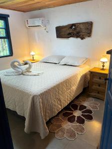 a bedroom with a bed and two tables and a window at Casa Ar Fresco in Sapiranga