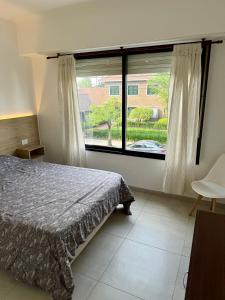 a bedroom with a bed and a large window at Departamento céntrico in Olavarría +9 photos