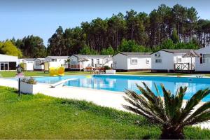 - une grande piscine dans une cour avec des maisons dans l'établissement Casa Nature's Avlis Bungalow 4XZ, à Pataias