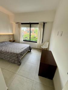 a bedroom with a bed and a large window at Departamento céntrico in Olavarría