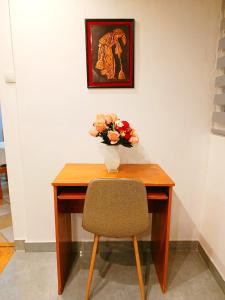 a wooden desk with a vase of flowers on it at Home Sweet Home No1 in Belgrade +6 photos