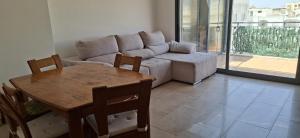 ein Wohnzimmer mit Sofa und Tisch in der Unterkunft Downtown apartment - Terrace, garage and pool in Olhão