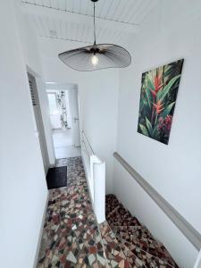 a hallway with a ceiling fan and a tile floor at Villa Mamina Martinique in Fort-de-France