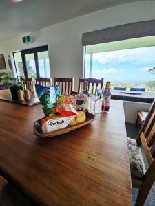 un plateau de nourriture assis sur une table en bois dans l'établissement Hosts on the Coast Tui Hills, à Aongatete