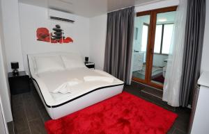 ヴァルナ・シティにあるPoshta 1 Apartment 1のベッドルーム1室(白いベッド1台、赤いラグ付)