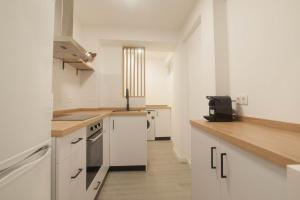Una cocina con gabinetes blancos y encimera. en 3 Bed Apt Sleep 6 - Pets Balcony Parking Wifi, en Ayamonte