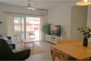 Una sala de estar con una mesa y un comedor. en 3 Bed Apt Sleep 6 - Pets Balcony Parking Wifi, en Ayamonte