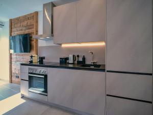 una cocina con armarios de acero inoxidable y fregadero en ALP'N SOUL - AlpenLuxus Collection, en Voldöpp