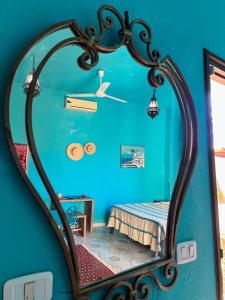 a mirror in a blue room with a bed at Dar Noor in Tozeur +55 photos