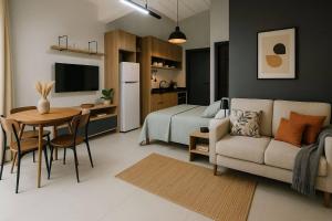 a living room with a couch and a table and a bed at Studio lindíssimo Vila do Lago- 900m da vila in Praia do Forte
