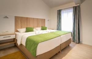 Awesome Home In Privlaka في Glavan: غرفة نوم بسرير كبير مع بطانية خضراء