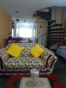eine Couch mit gelben Kissen in einem Wohnzimmer in der Unterkunft Casa no Condomínio Moana - Praia Martins de Sá in Caraguatatuba