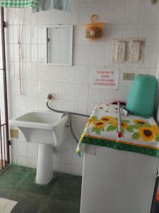 ein kleines Badezimmer mit Waschbecken und Toilette in der Unterkunft Casa no Condomínio Moana - Praia Martins de Sá in Caraguatatuba