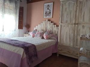 グラナダにあるLa casita de Paco Albaicinのベッドルーム1室(ベッド1台付)、大きな木製キャビネットが備わります。
